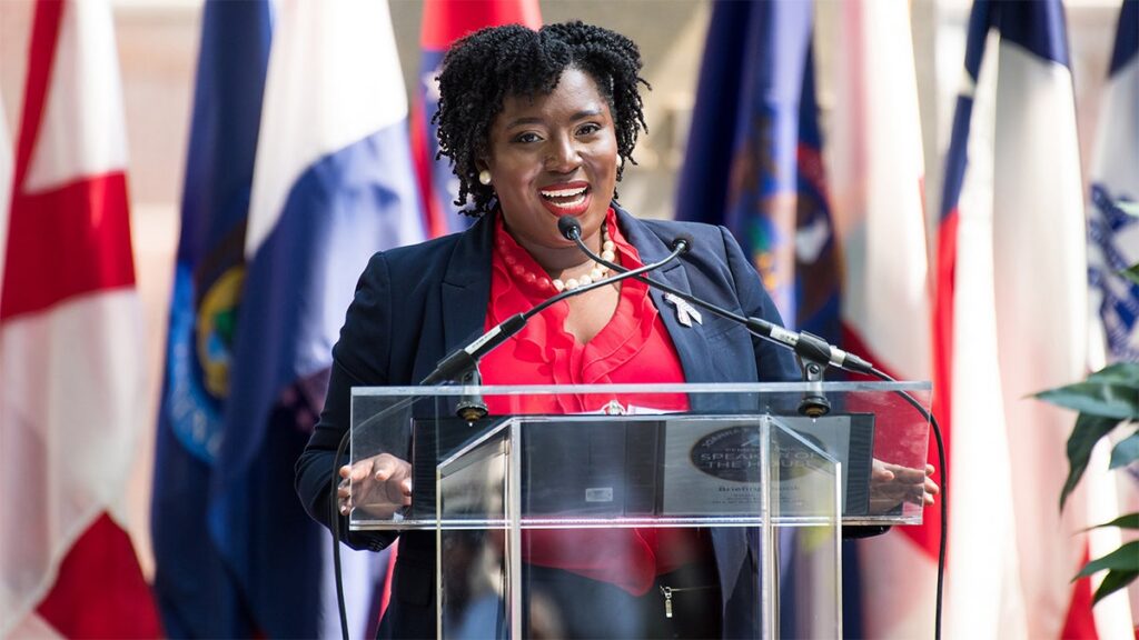 joanna-mcclinton-speaks-at-podium.jpgve1tl1