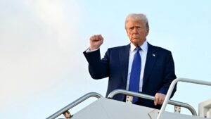 trump-holds-out-fist-after-stepping-off-air-force-one-at-palm-beach-international-airport-february-2025.jpgve1tl1